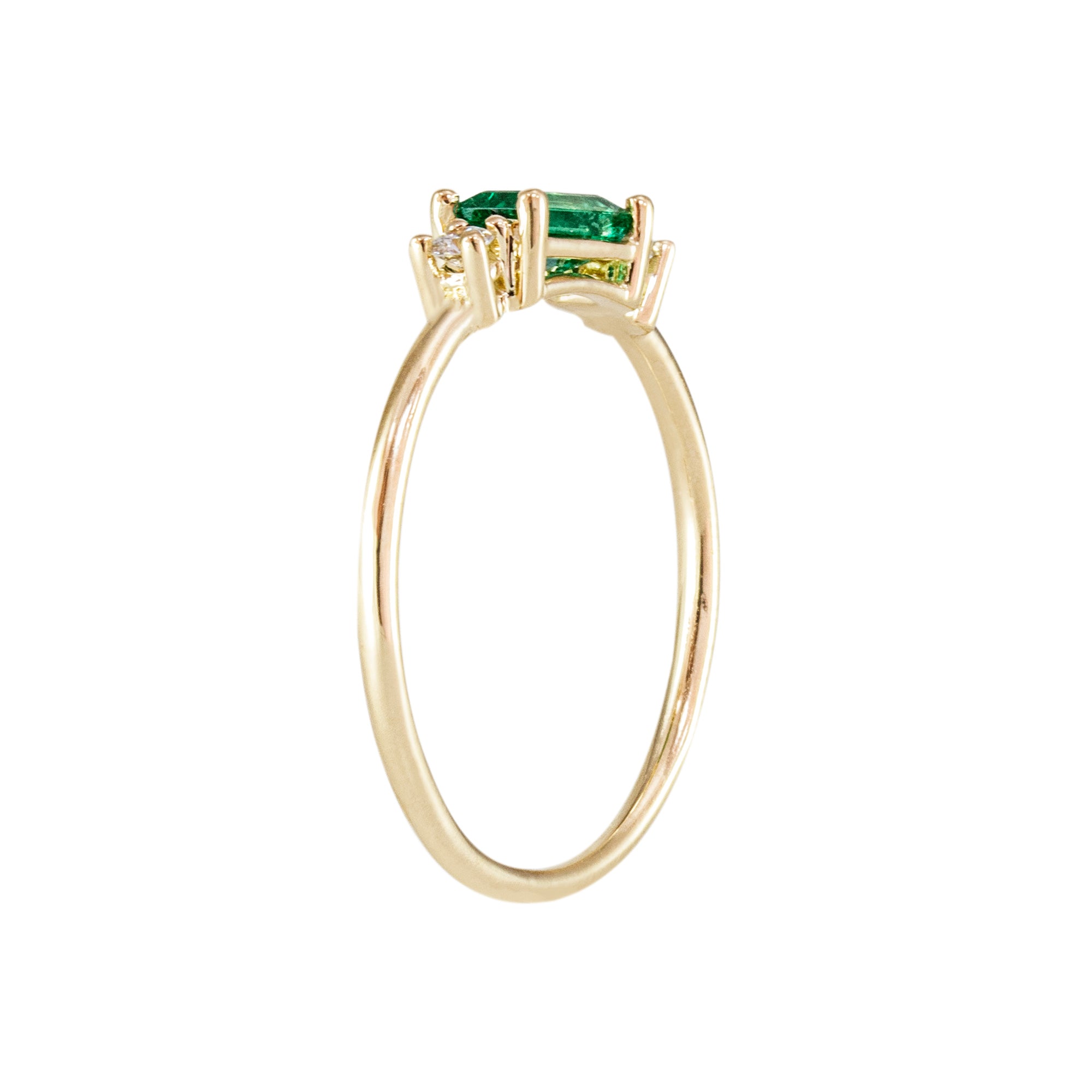 Anillo oro 18K trilogía de esmeralda y diamantes en fondo blanco
