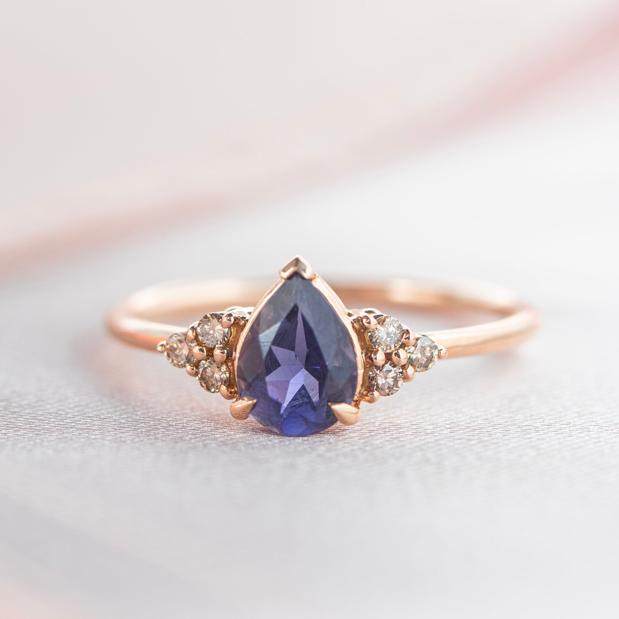 Trilogía oro 18kt, Iolita talla pera, Diamante natural color Brown, Montura 3 grapas con grapa tipo garra para dar protagonismo a las piedras, Aro hilo redondo.