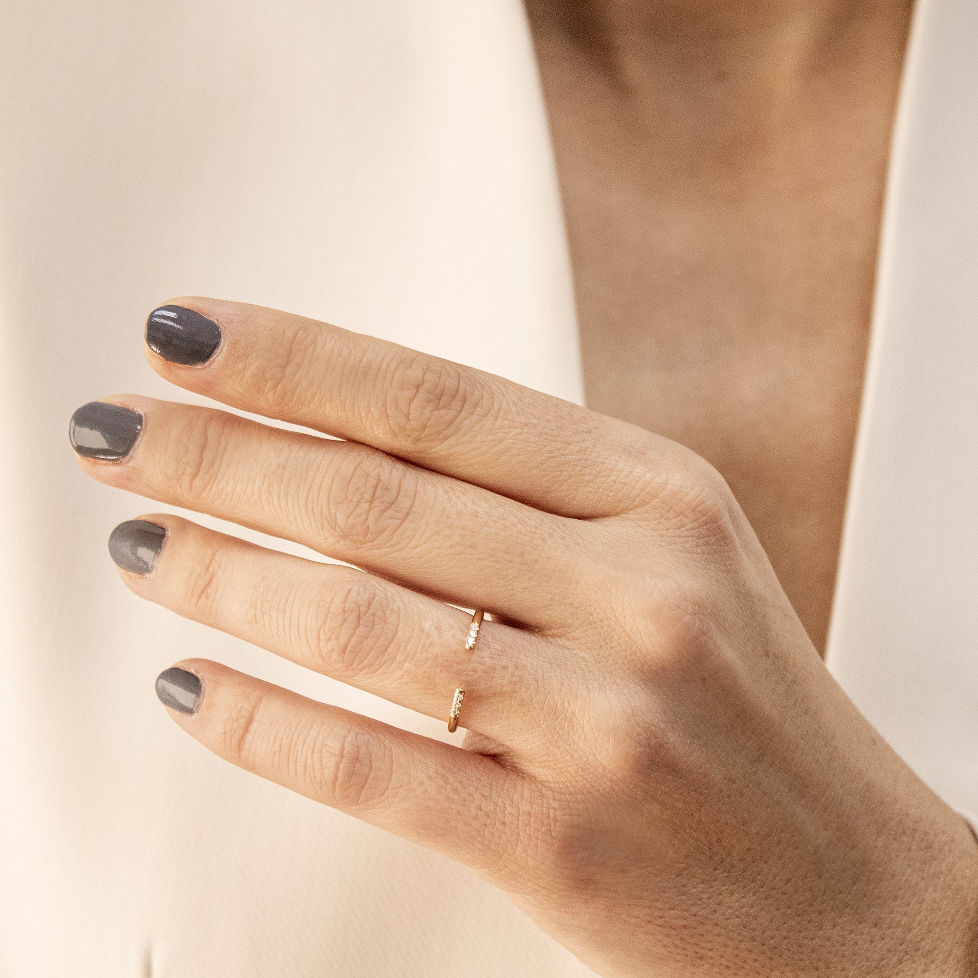 Anillo abierto en oro 18K con diamantes en la mano de una mujer