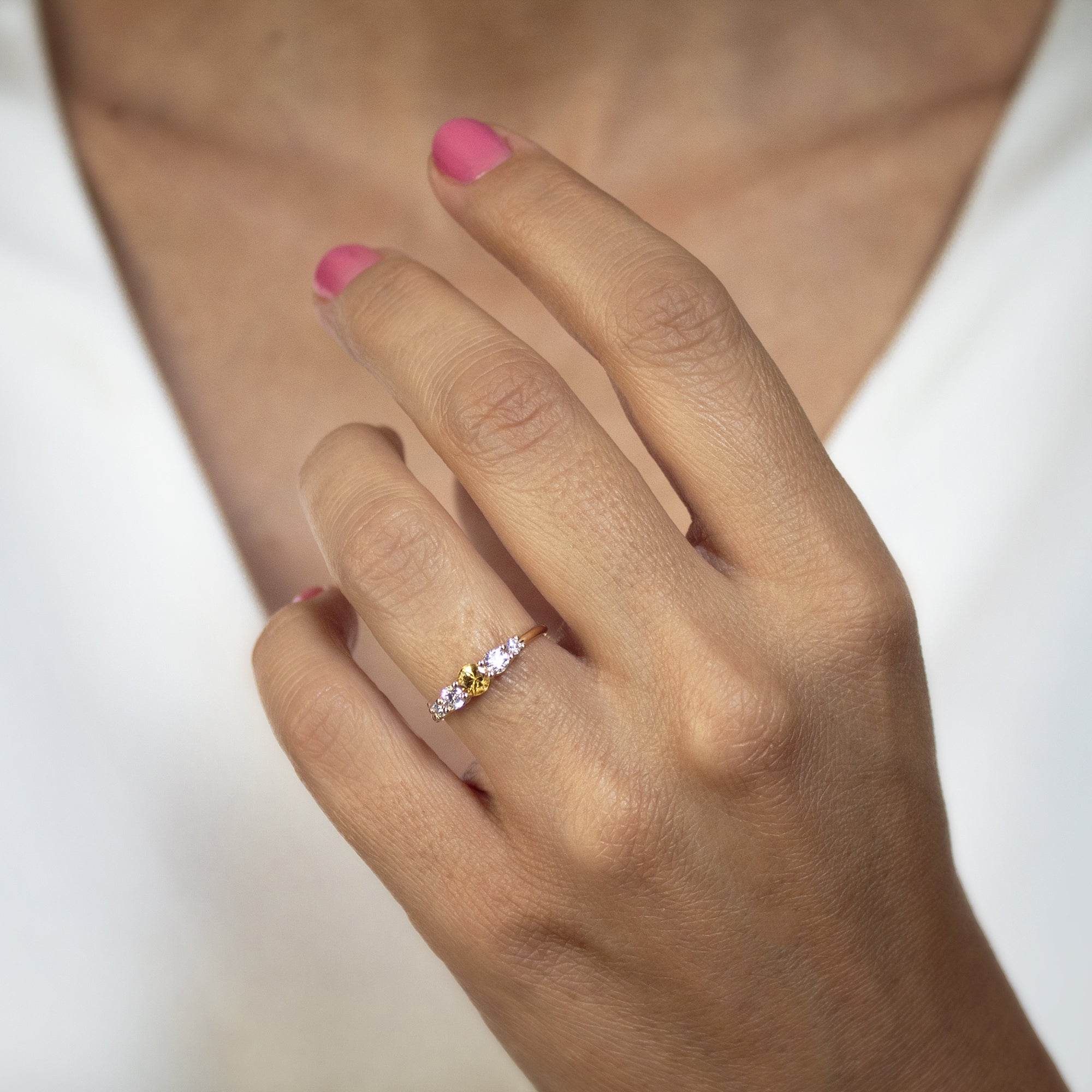 Anillo de Oro 18K con zafiro amarillo y diamantes en la mano de una mujer